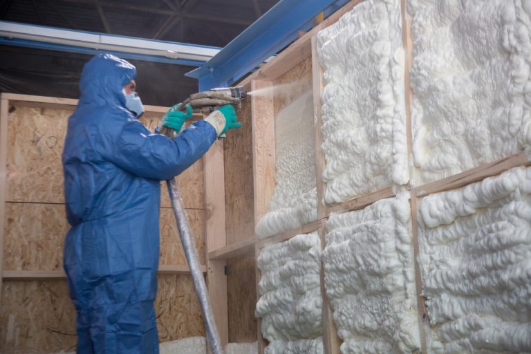 Spray foam insulation expert applying foam to the walls