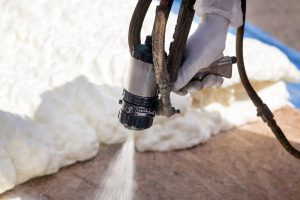 Technician spraying foam insulation using a spray gun