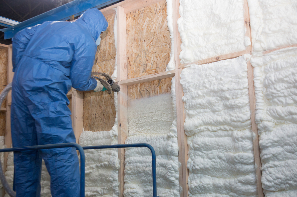 The worker insulates the walls of the house with foam for sound insulation and heat